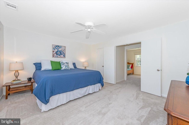 bedroom with visible vents, light colored carpet, and baseboards