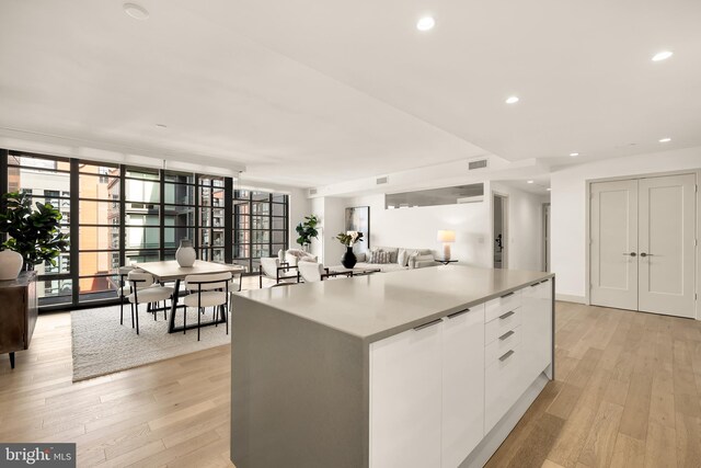 kitchen featuring white cabinetry, light wood-style flooring, modern cabinets, plenty of natural light, and floor to ceiling windows