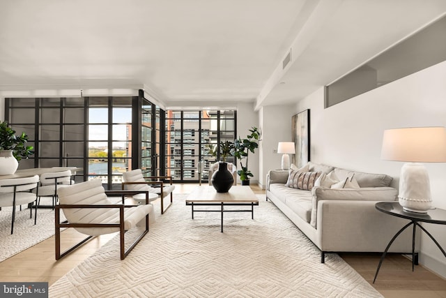 living room featuring expansive windows, wood finished floors, and baseboards