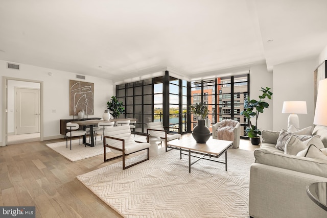 living area with wood-type flooring and a wall of windows