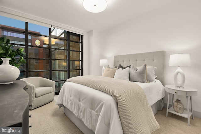 carpeted bedroom featuring a wall of windows