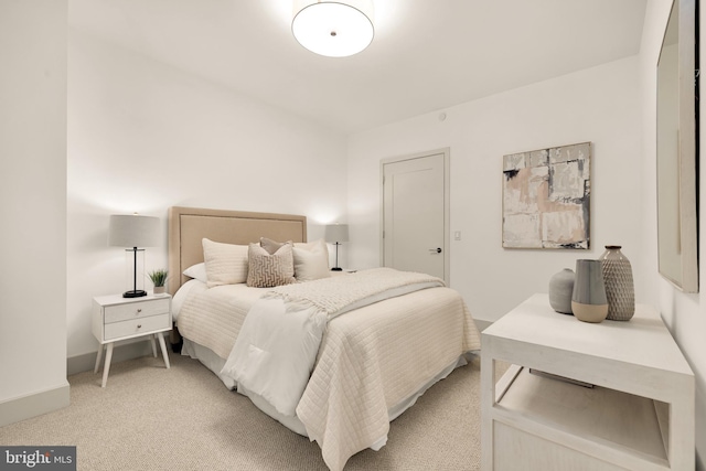 bedroom featuring light carpet and baseboards