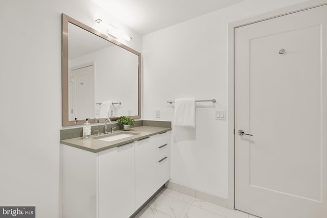 bathroom with marble finish flooring, vanity, and baseboards