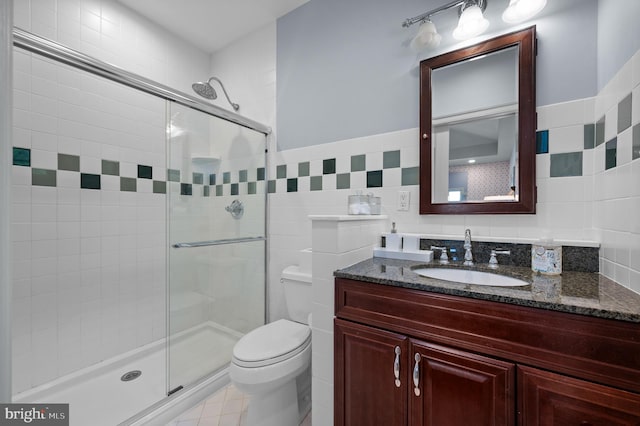 full bath with tile walls, a shower stall, and toilet