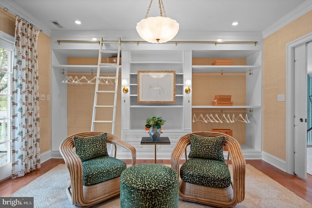 living area with visible vents, baseboards, recessed lighting, ornamental molding, and wood finished floors
