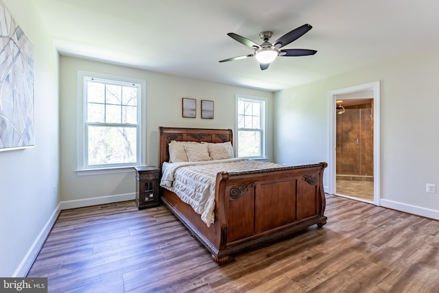 bedroom featuring baseboards, ensuite bathroom, a ceiling fan, and wood finished floors