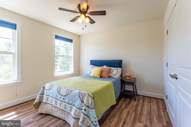 bedroom featuring baseboards, ceiling fan, and wood finished floors