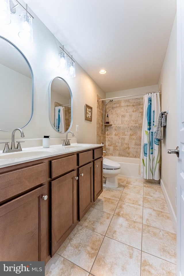 bathroom featuring double vanity, a sink, tile patterned floors, and toilet