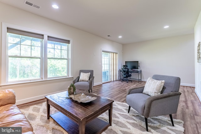 living room with visible vents, recessed lighting, and wood finished floors