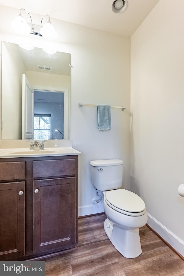 bathroom with visible vents, baseboards, and wood finished floors
