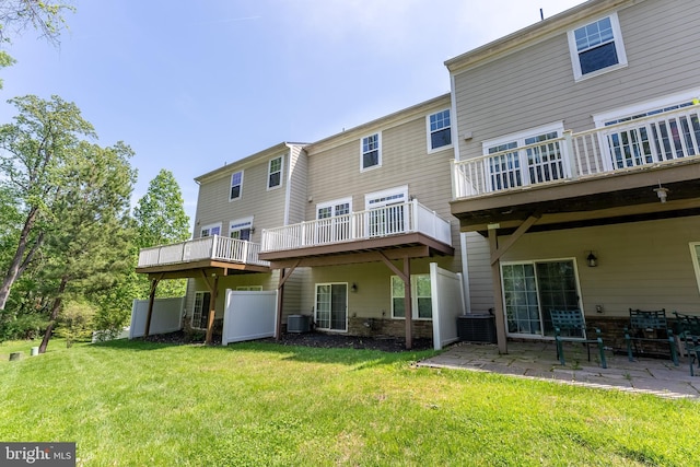 back of house with a lawn, a patio area, and central AC
