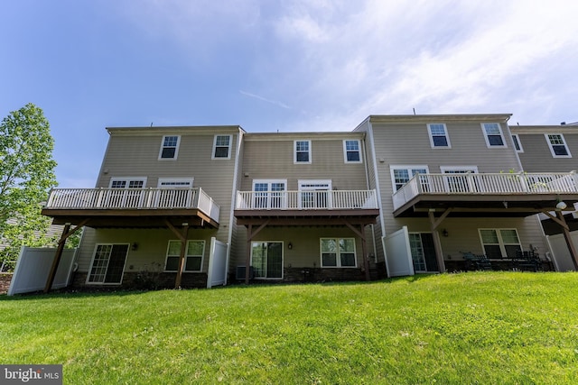 rear view of property with a yard and a wooden deck
