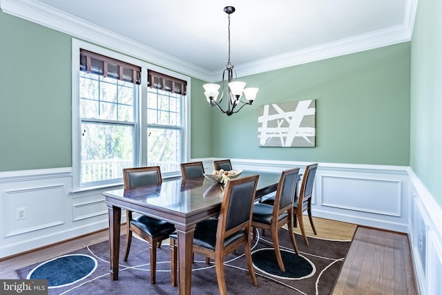 dining area featuring crown molding, a chandelier, dark wood-style floors, and a wealth of natural light
