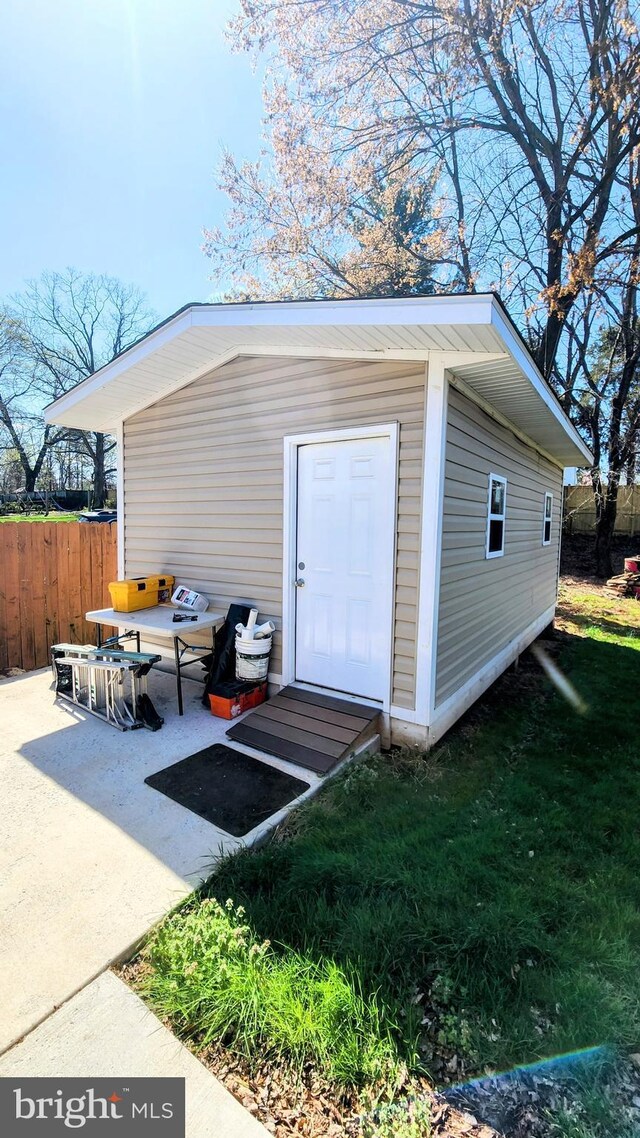 view of outbuilding with fence and an outdoor structure
