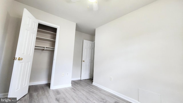 unfurnished bedroom with ceiling fan, baseboards, wood finished floors, and a closet