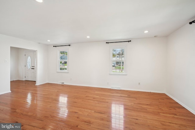 spare room featuring baseboards, visible vents, light wood-type flooring, and recessed lighting