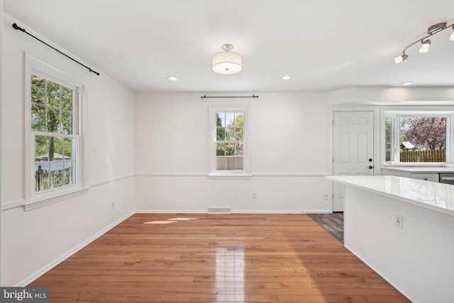 unfurnished dining area with baseboards, recessed lighting, visible vents, and light wood-style floors
