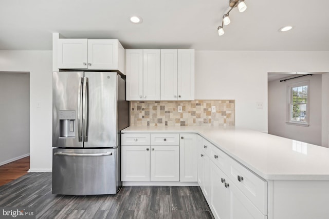 kitchen with dark wood-style floors, stainless steel refrigerator with ice dispenser, a peninsula, light countertops, and white cabinets
