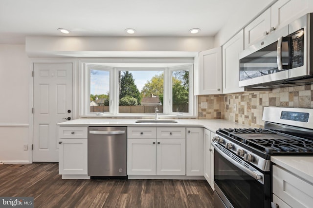 kitchen featuring tasteful backsplash, a sink, stainless steel appliances, light countertops, and dark wood-style floors