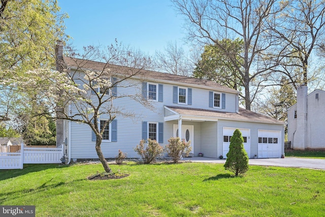 traditional-style house with fence, driveway, and a front lawn