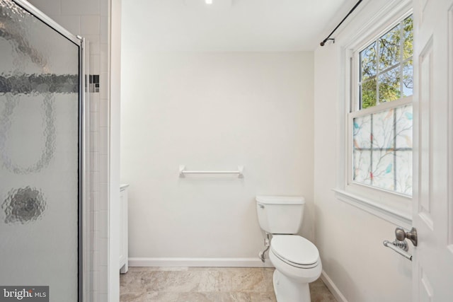 full bathroom featuring toilet, tile patterned flooring, a stall shower, and baseboards