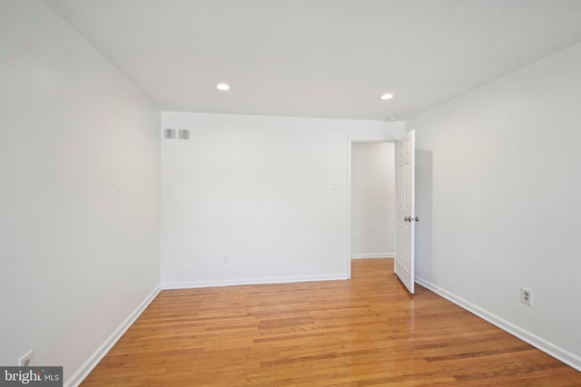 unfurnished room with recessed lighting, light wood finished floors, visible vents, and baseboards