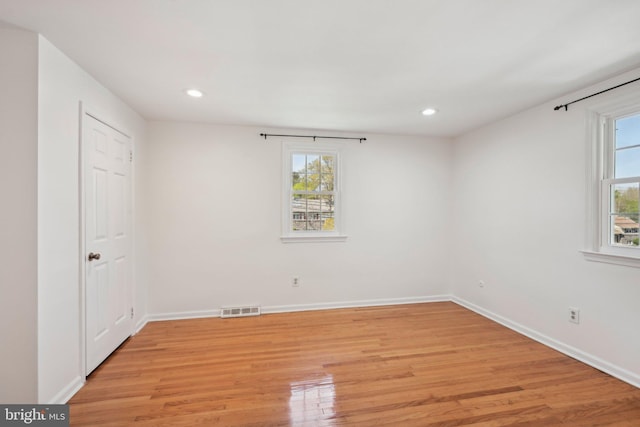 unfurnished bedroom with visible vents, multiple windows, and light wood finished floors