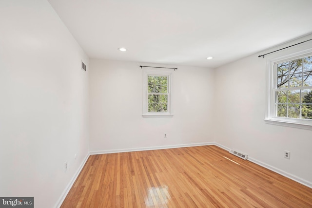 unfurnished room featuring visible vents, light wood-type flooring, recessed lighting, and baseboards
