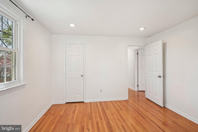 unfurnished bedroom with light wood-type flooring, recessed lighting, multiple windows, and baseboards