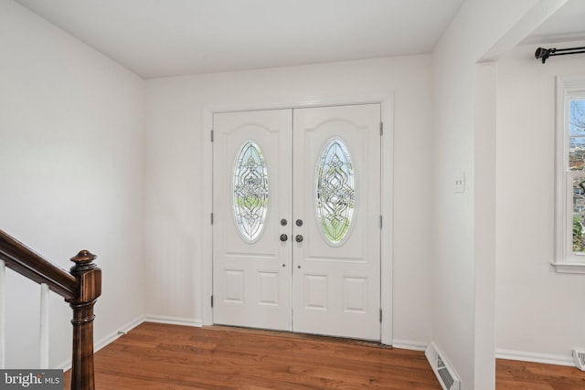 entryway featuring a wealth of natural light, visible vents, wood finished floors, and baseboards