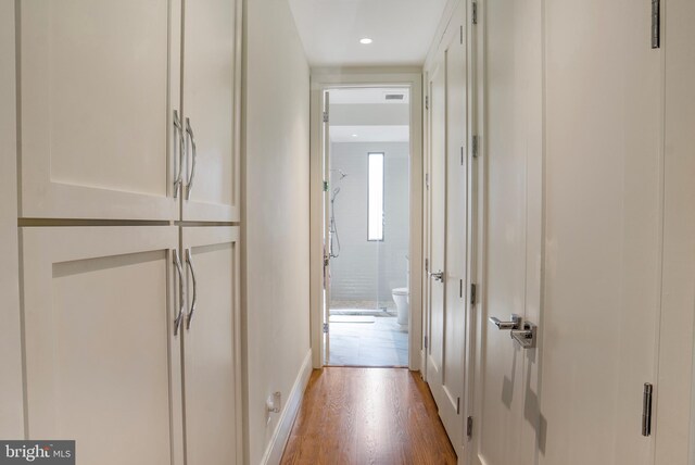 corridor featuring baseboards, recessed lighting, and wood finished floors