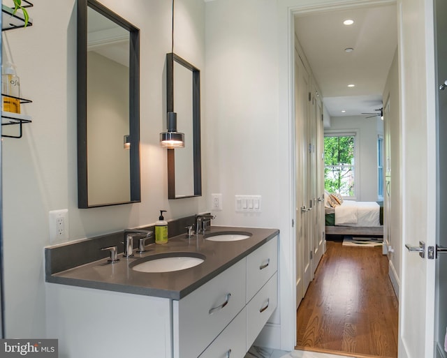 full bath with recessed lighting, a sink, wood finished floors, and double vanity