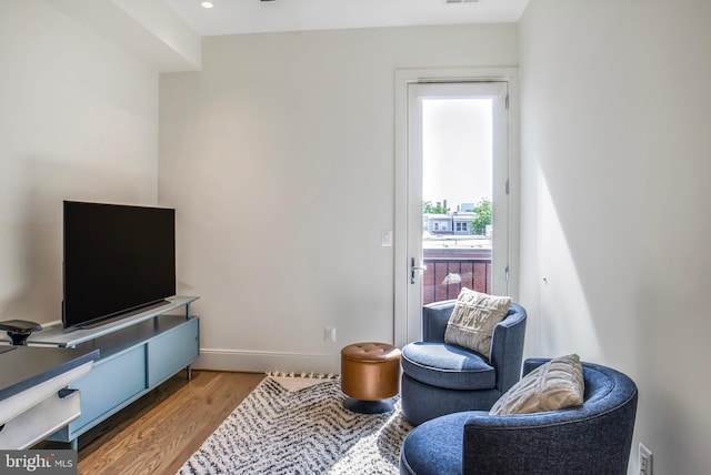 living area with baseboards and wood finished floors