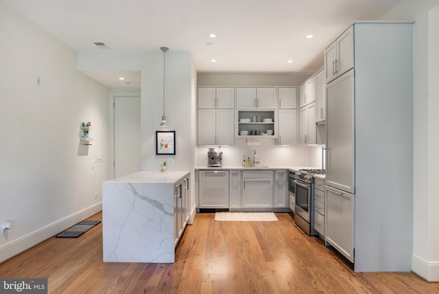 kitchen featuring a sink, dishwasher, stainless steel range with gas cooktop, a peninsula, and decorative backsplash