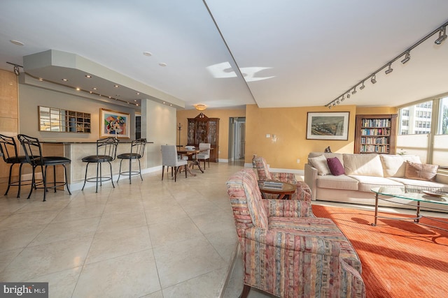 living room with baseboards, light tile patterned floors, and track lighting