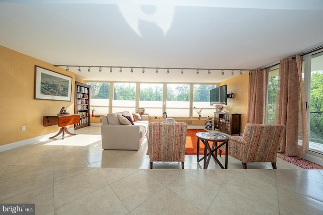 living area featuring track lighting, baseboards, and tile patterned floors