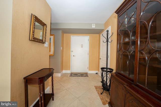 interior space featuring light tile patterned flooring and baseboards