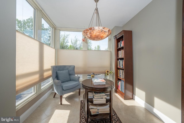sitting room featuring baseboards, tile patterned floors, and a wealth of natural light