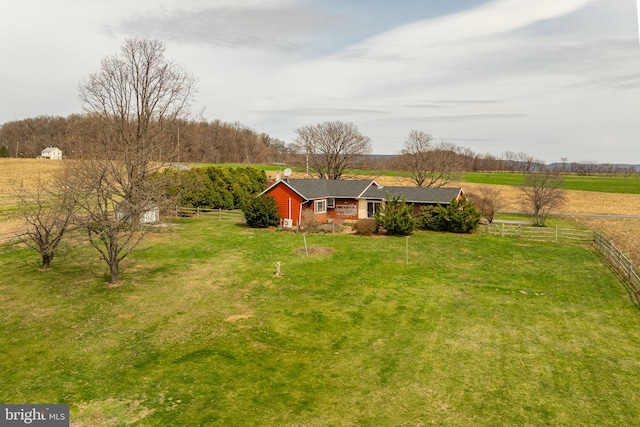 view of yard with fence and a rural view