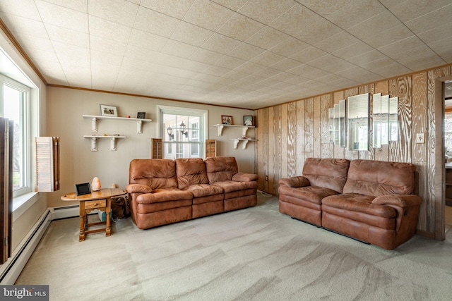 carpeted living room featuring plenty of natural light, a baseboard heating unit, and wooden walls
