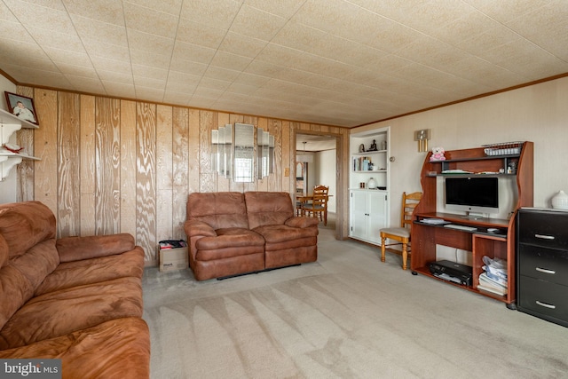 carpeted living room featuring ornamental molding and wood walls