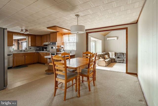 dining area featuring wooden walls, light colored carpet, and a wall unit AC