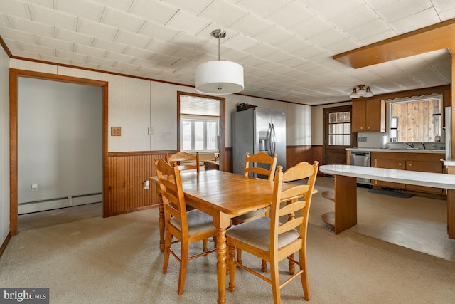 dining area featuring a wainscoted wall, baseboard heating, and a wealth of natural light