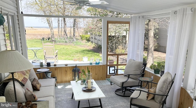 sunroom / solarium with plenty of natural light, a ceiling fan, and an outdoor living space