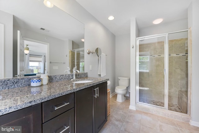 bathroom featuring vanity, toilet, tile patterned floors, a shower stall, and visible vents