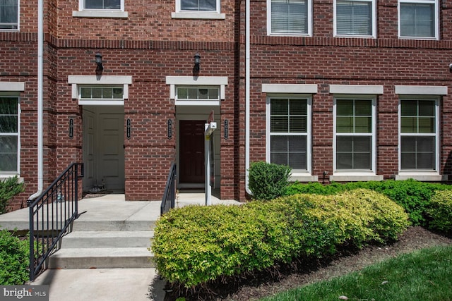 view of exterior entry featuring brick siding