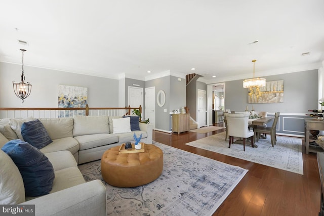 living room featuring an inviting chandelier, ornamental molding, dark wood-style flooring, visible vents, and recessed lighting