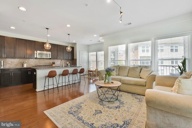living room featuring recessed lighting, wood finished floors, and visible vents