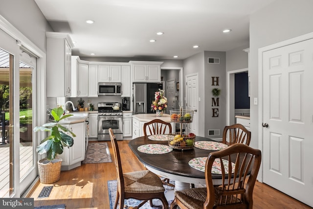 dining room featuring wood finished floors, recessed lighting, and visible vents