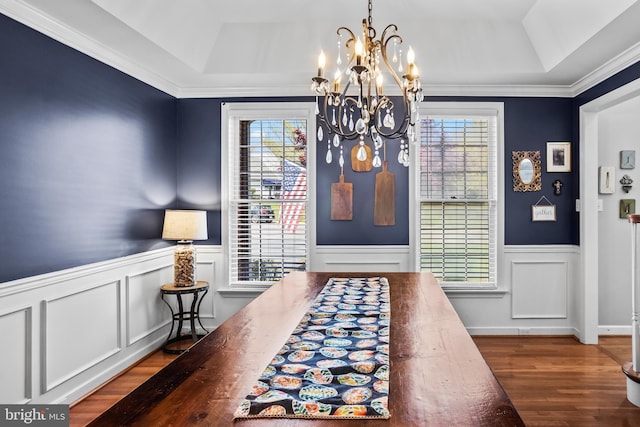 dining area featuring a chandelier, wood finished floors, and a tray ceiling